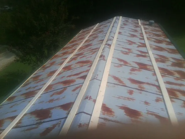 Rusted metal roof panels with new wood purlins before replacement — Storm Damage Roof Repair in Islandia by Roofing Brothers