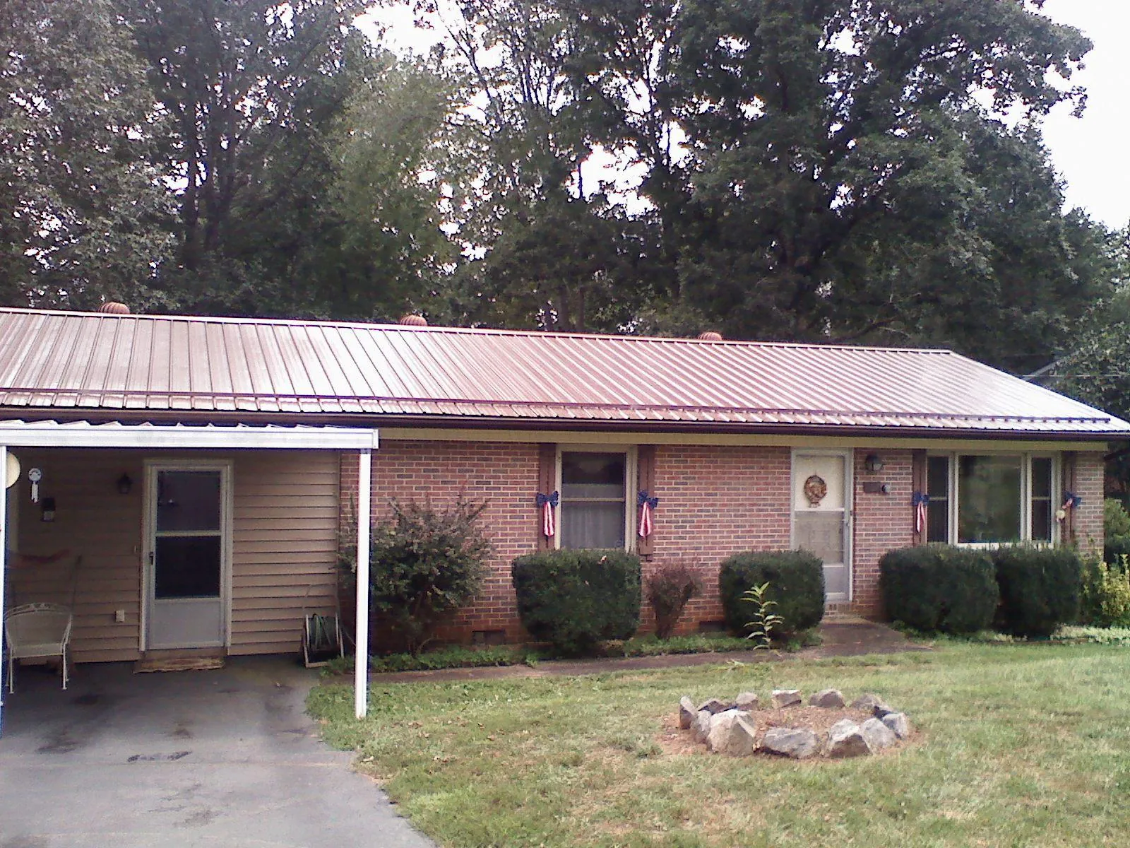 Bronze metal roof and carport on a brick ranch home — Roof Repair work by our crew in Islandia